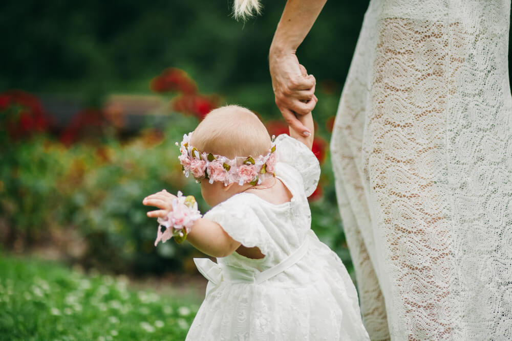 bébé qui porte une robe blanche